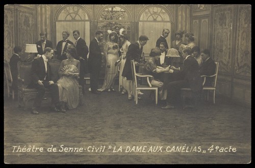 Download the full-sized image of French or Belgian prisoners of war, some in drag, posing on stage during a crowded scene of "La dame aux camélias"; at Sennelager prisoner of war camp in Germany. Photographic postcard, 191-.