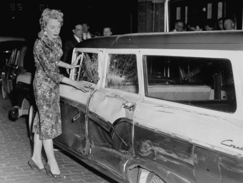 Download the full-sized image of Christine Jorgensen Examines a Damaged Car