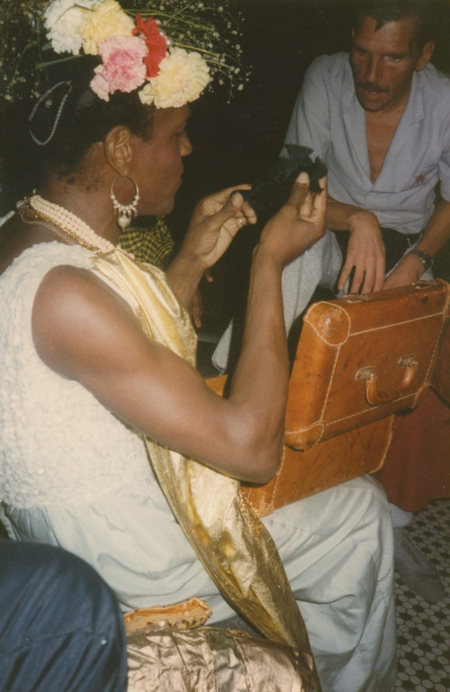 Download the full-sized image of A Photograph of Marsha P. Johnson Opening a Present at Her Birthday Party, With a Leather Box on Her Lap