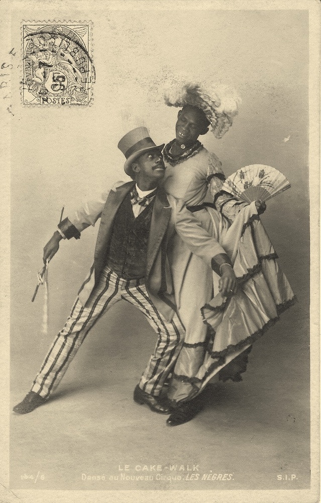 Download the full-sized image of Jack Brown Poses in Drag Holding Skirt and Fan, with Dance Partner Charles Gregory