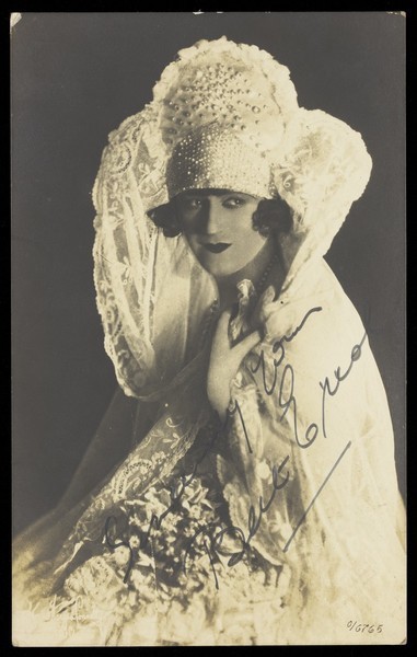 Download the full-sized image of Bert Errol, in character, wearing an elaborate white dress. Process print, 1925.