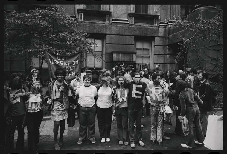 Download the full-sized image of A Photograph of Gay Liberation Front Members Hugging Wearing Shirts that Spell Out "GAY POWER" Featuring Marsha P. Johnson and Sylvia Rivera