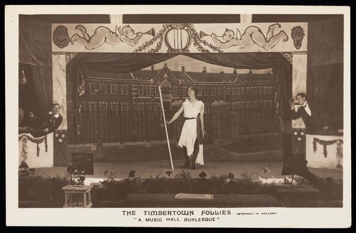Download the full-sized image of British prisoners of war, one in drag, posing for "The Timbertown Follies", at a prisoner of war camp in Groningen. Photographic postcard, 191-.