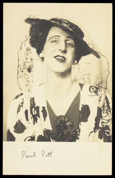 Download the full-sized image of Paul Pitt in drag, posing in flowery garments. Photographic postcard, 194-.