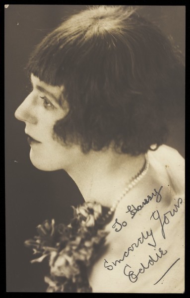 Download the full-sized image of Eddie, a man in drag poses for a close-up, wearing a pearl necklace and styled hair. Photographic postcard, ca. 1925.
