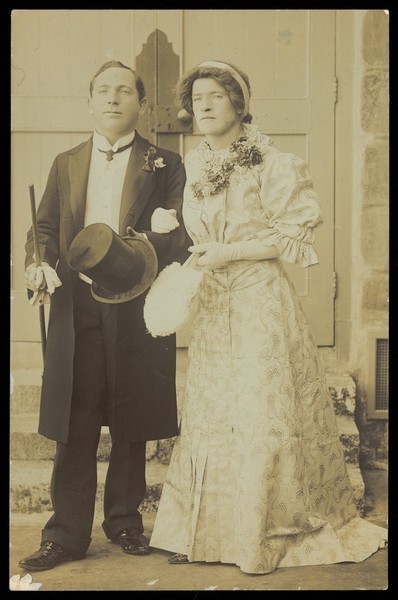Download the full-sized image of Two men, one in drag, dressed as bride and groom. Photographic postcard, 191-.