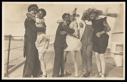 Download the full-sized image of Sailors, some in drag, pose as three couples on the deck of a ship. Photographic postcard, 192-.
