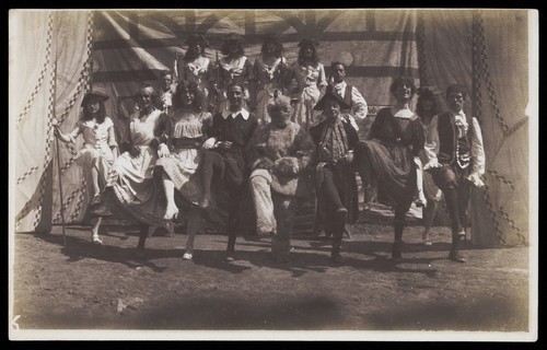 Download the full-sized image of British servicemen dancing in a line, some are in drag. Photograph, ca. 1918.