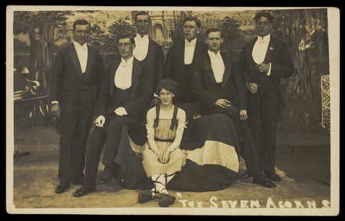Download the full-sized image of Seven men on stage set of "The seven acorns". Photographic postcard, 1918-1920.