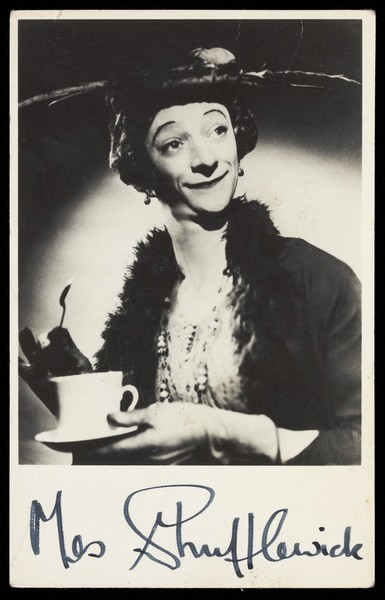 Download the full-sized image of Mrs. Shufflewick (Rex Jameson), in drag character, holding a cup of tea. Photograph, ca. 1955.