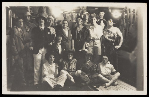 Download the full-sized image of Passengers on RMS Armadale Castle, some in drag, pose for a group portrait. Photographic postcard, 1933.