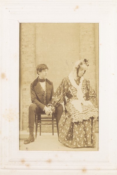 Download the full-sized image of Two men, one in drag, sitting next to each other. Photograph, 189-.