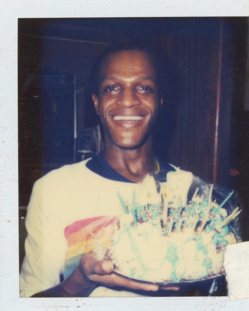 Download the full-sized image of A Photograph of Marsha P. Johnson Smiling and Holding Up a Birthday Cake