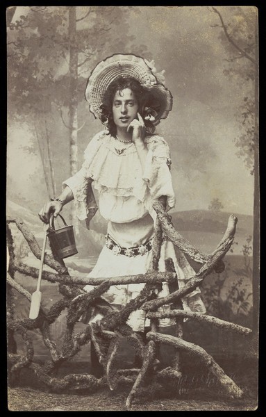 Download the full-sized image of A sailor in drag, wearing a milkmaid costume. Photographic postcard by H.J. Bond, 1906.
