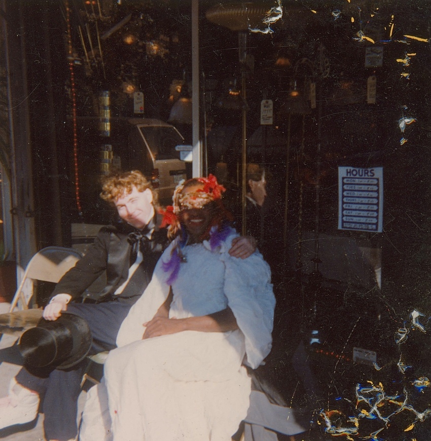 Download the full-sized image of A Photograph of Marsha P. Johnson Sitting with a Friend Wearing a White Dress and Floral Headpiece
