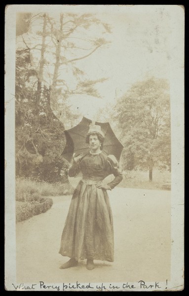 Download the full-sized image of Harry Hawksbee in drag posing in a park. Photographic postcard, 1914.